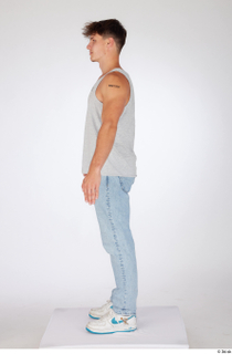 Darren a-poses blue jeans casual dressed grey tank top standing…